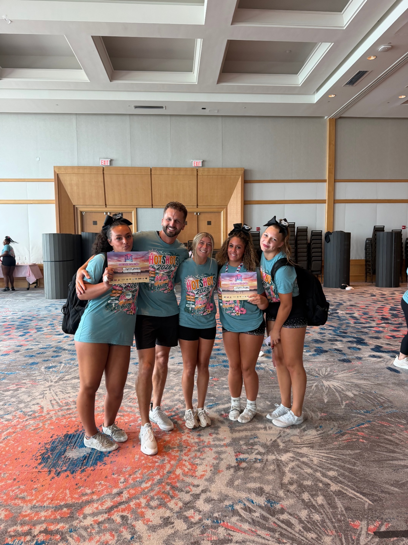 Athletes holding award certificates with coach